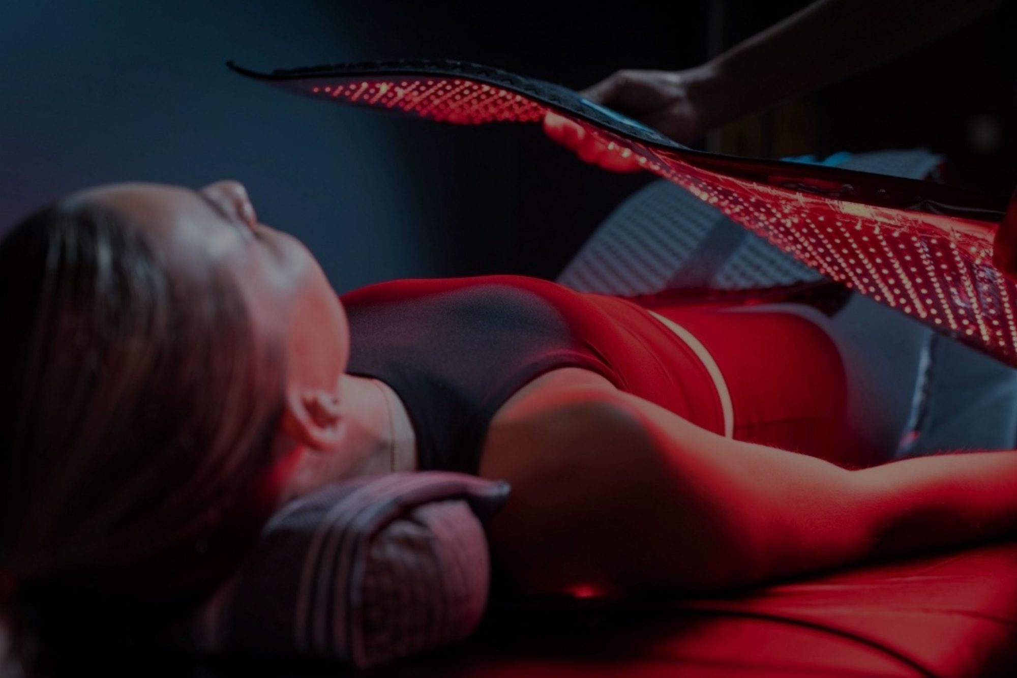 A member relaxing under the Red Light Method system while a team member positions the light panel.