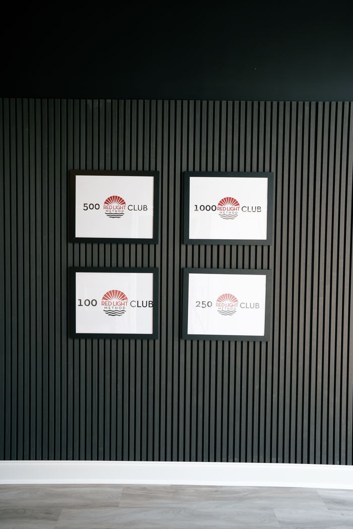 Framed 100, 250, 500 and 1000 Club plaques on the slatted wall by the front desk.