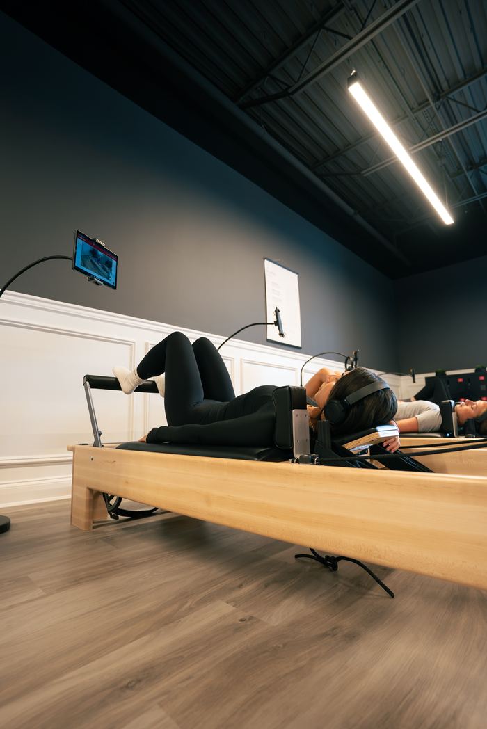 Members working through a session on the Pilates reformers.