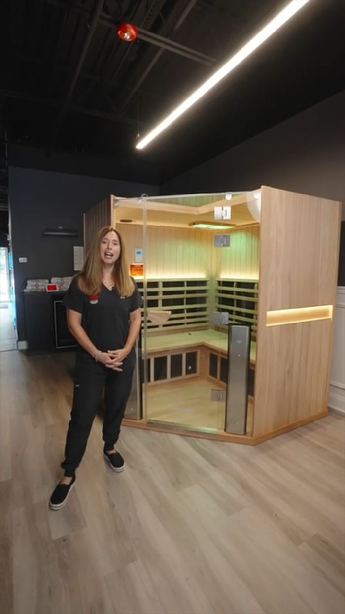 Karen standing in front of the far infrared sauna cabin.